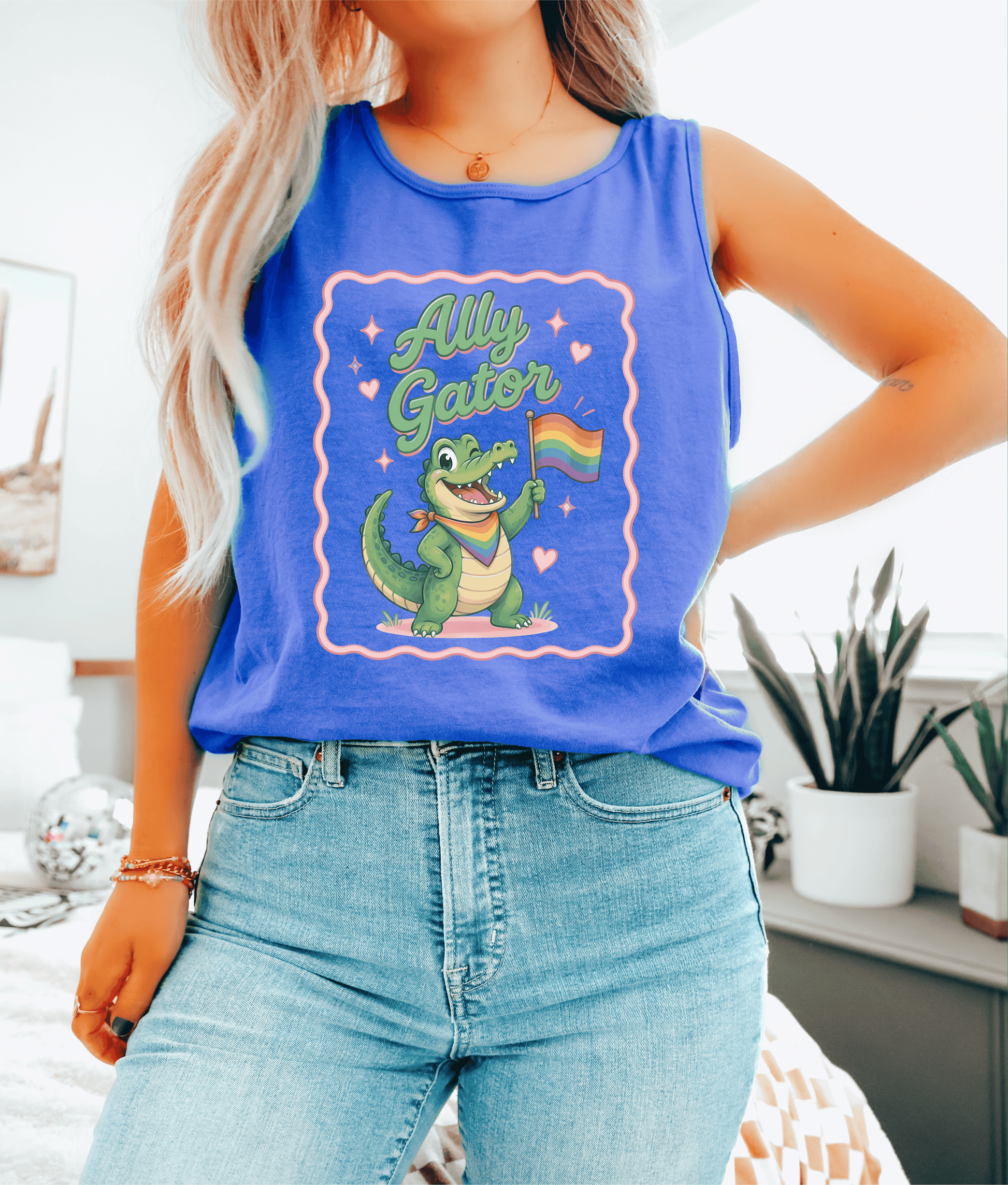 Person wearing a blue tank top with a graphic of a crocodile holding a rainbow flag and the text 'Ally Gator'.