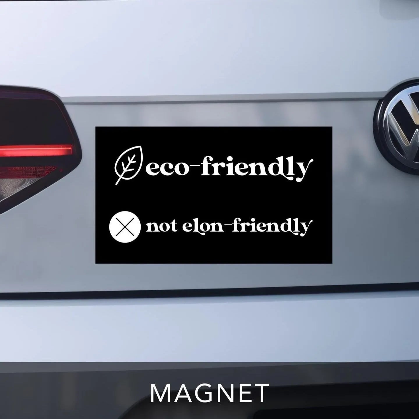 car bumper magnet in black and white reads &quot;eco-friendly&quot; with leaf graphic on top line.  Bottom line reads &quot;not elon-friendly&quot; with X graphic next to it.  Anti-Elon Musk Bumper Sticker