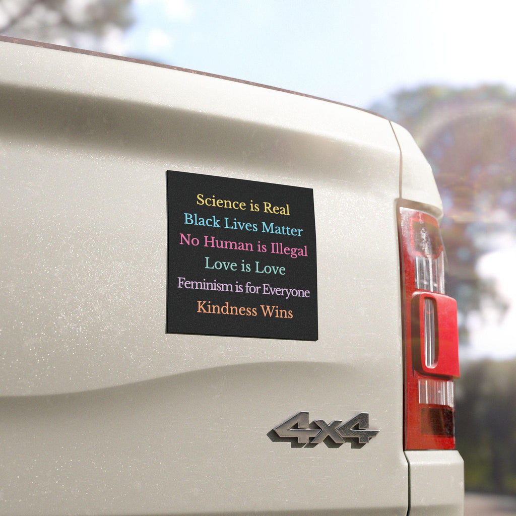 Square car bumper magnet with black background and pastel text reading: “Science is real, Black Lives Matter, Love is Love, No Human is Illegal, Feminism is for Everyone, Kindness Wins.”