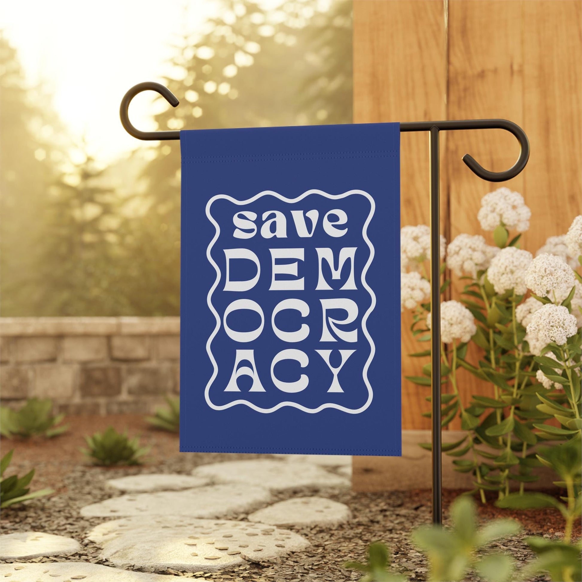 Blue garden flag with wavy white border and bold white text reading “Save Democracy.”