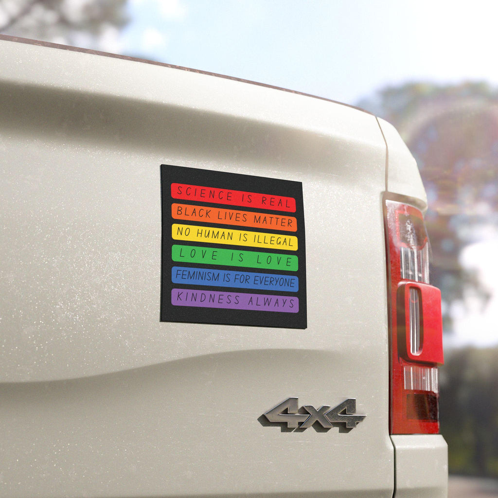 Square bumper magnet in rainbow blocks reading “Science is Real, Black Lives Matter, No Human is Illegal, Love is Love, Feminism is for Everyone, Kindness Always”